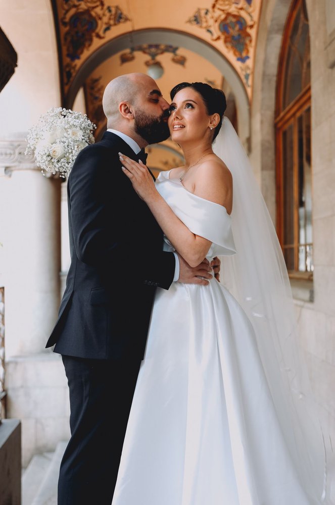 Sofia and James embracing in the doorway of The Old Rectory, analogue photograph
